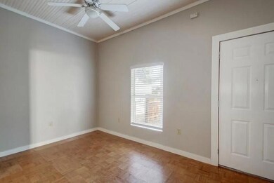 Empty room featuring baseboards, crown molding, a
