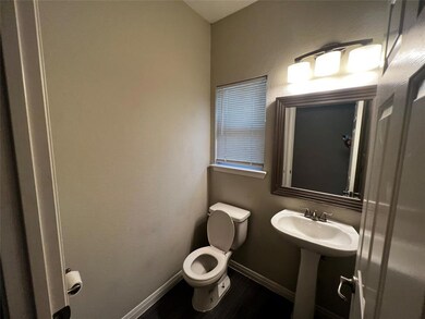 Half bath featuring baseboards, wood finished flo