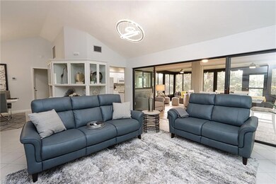 Living room with high vaulted ceiling, ceiling fan, and light tile floors