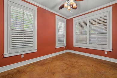 Empty room featuring a ceiling fan, crown molding