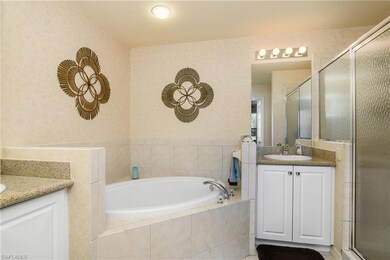 Bathroom featuring two vanities, a shower stall, and a bath