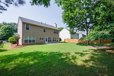 Rear view of house featuring a patio area and a chimney