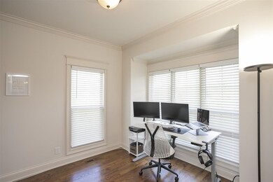 Across the hall is an office with tall windows for