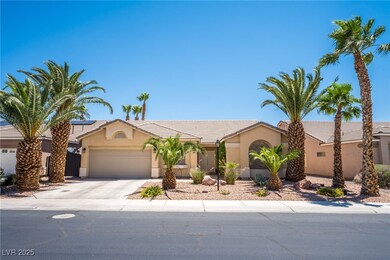 View of front of home with a 2 car garage, mature