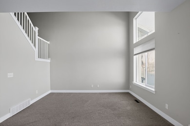 Empty room with carpet floors and a towering ceiling