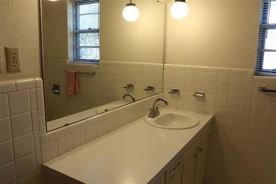 Bathroom featuring tile walls, vanity, and plenty 