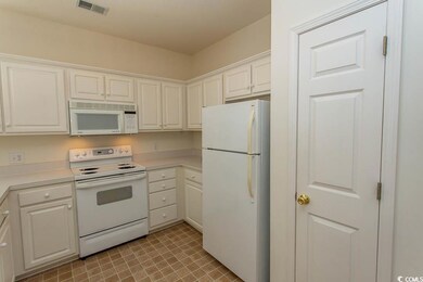 Kitchen featuring white cabinetry and white applia