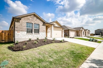 Ranch-style home with concrete driveway, stone si