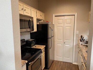 Kitchen featuring white cabinetry, backsplash, sta