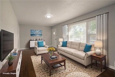 Living room featuring dark wood finished floors and a textured ceiling
