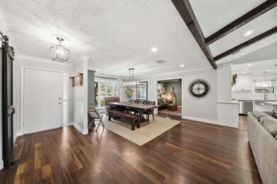 Featuring gorgeous luxury laminate hardwood flooring throughout the home, the foyer of the home with crown moulding includes a hanging light fixture. Beautiful paint color selections are highlighted by replaced solid wood interior doors & hardware, baseboards, window trim, dimmable recessed lighting and electrical switch plates & outlets throughout the home.