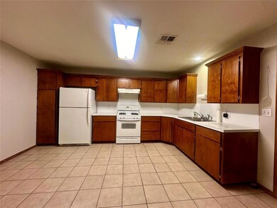 Kitchen featuring white appliances, light tile patterned floors, and sink