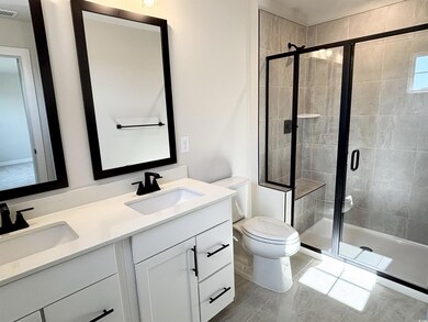 Bathroom featuring a sink, toilet, and a shower st