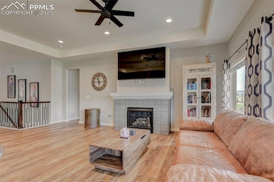 Living area featuring ceiling fan, wood finished f