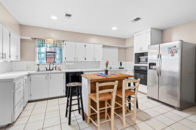 Kitchen featuring visible vents, backsplash, black