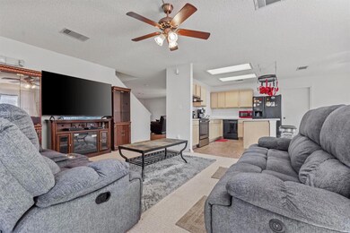 Living area featuring ceiling fan, a textured cei