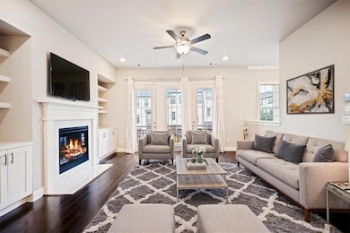 Living area featuring a ceiling fan, dark wood-style flooring, a fireplace, baseboards, and recessed lighting