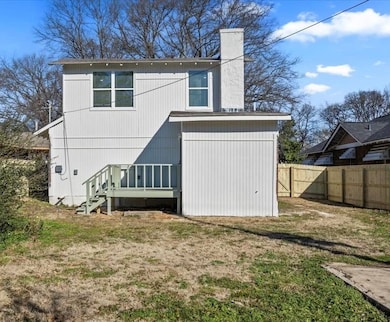Back of property featuring a fenced backyard, a chimney, and stairway
