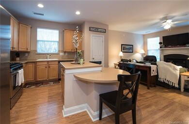 Kitchen island with comfortable seating.  Tile bac