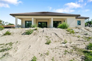Rear view of property with stucco siding and a tiled roof