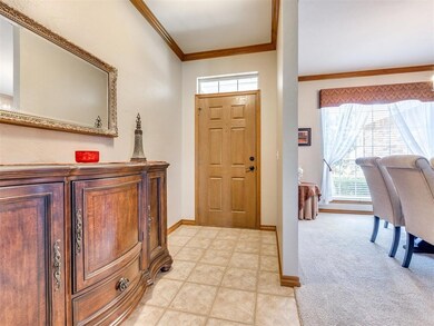 Foyer featuring crown molding and baseboards