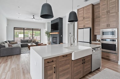 Kitchen with a sink, light wood-style floors, lig