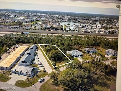 Aerial view of residential area with property boundaries highlighted and a nearby body of water