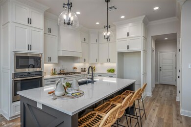 Kitchen featuring custom range hood, tasteful back