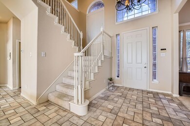Tiled foyer with a high ceiling and a chandelier