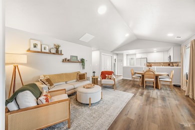 Living room featuring vaulted ceiling, light wood finished floors, and recessed lighting