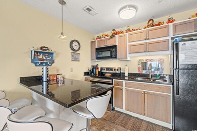 Kitchen with black appliances, a breakfast bar, da