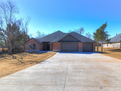 View of front of home with brick siding, a garage,
