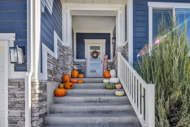 View of exterior entry with stone siding and a porch