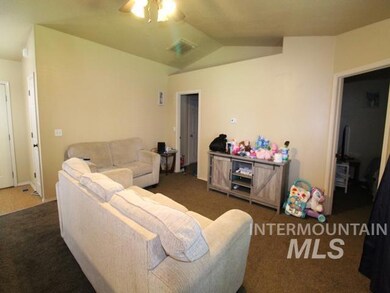 Living area with carpet, a ceiling fan, and vaulted ceiling