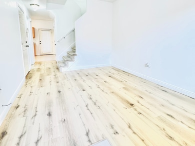 Unfurnished room with light wood-style flooring, stairs, and ceiling fan
