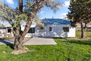 Rear view of property with a lawn and roof with shingles