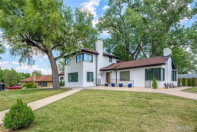 View of front of house with a chimney and a front yard