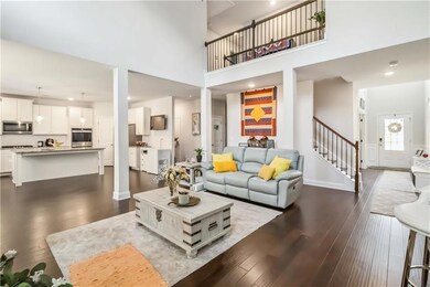 Living room featuring dark wood-style floors, stairway, a towering ceiling, and recessed lighting