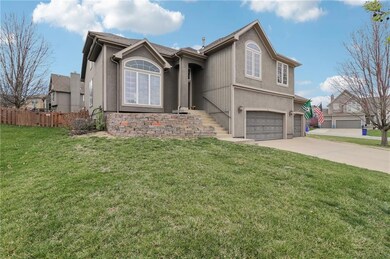 View of front facade featuring stucco siding, driveway, a garage, and fence