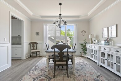 Dining space with LVP, a chandelier, a raised ceil