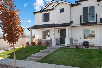 View of front facade featuring stone siding, board and batten siding, a porch, and a balcony