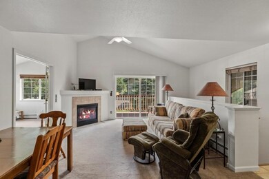 Carpeted living room with vaulted ceiling, a baseb