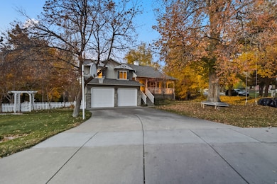 View of front facade with concrete driveway, a garage, a shingled roof, a chimney, and covered porch
