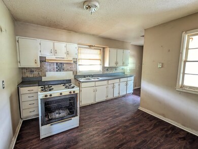 Kitchen with white gas stove, dark hardwood / wood