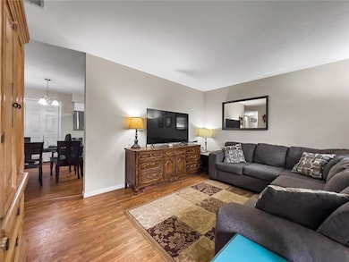 Living area with a chandelier, baseboards, and lig