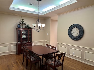 Elegant dining room featuring warm wood flooring,