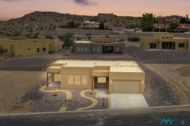 Pueblo revival-style home featuring stucco siding, a mountain view, a garage, and driveway