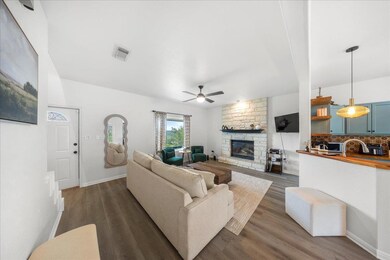 Living room with a ceiling fan, a fireplace, dark