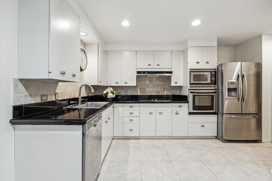 This kitchen features sleek white cabinetry, black