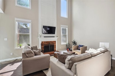 Living room featuring a towering ceiling, dark hardwood / wood-style flooring, and a fireplace